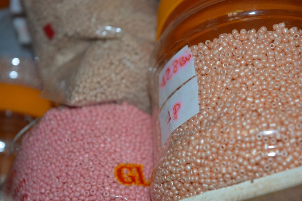 Second plan de travail de l’atelier : coupelles et bocaux de perles, fils et aiguilles.